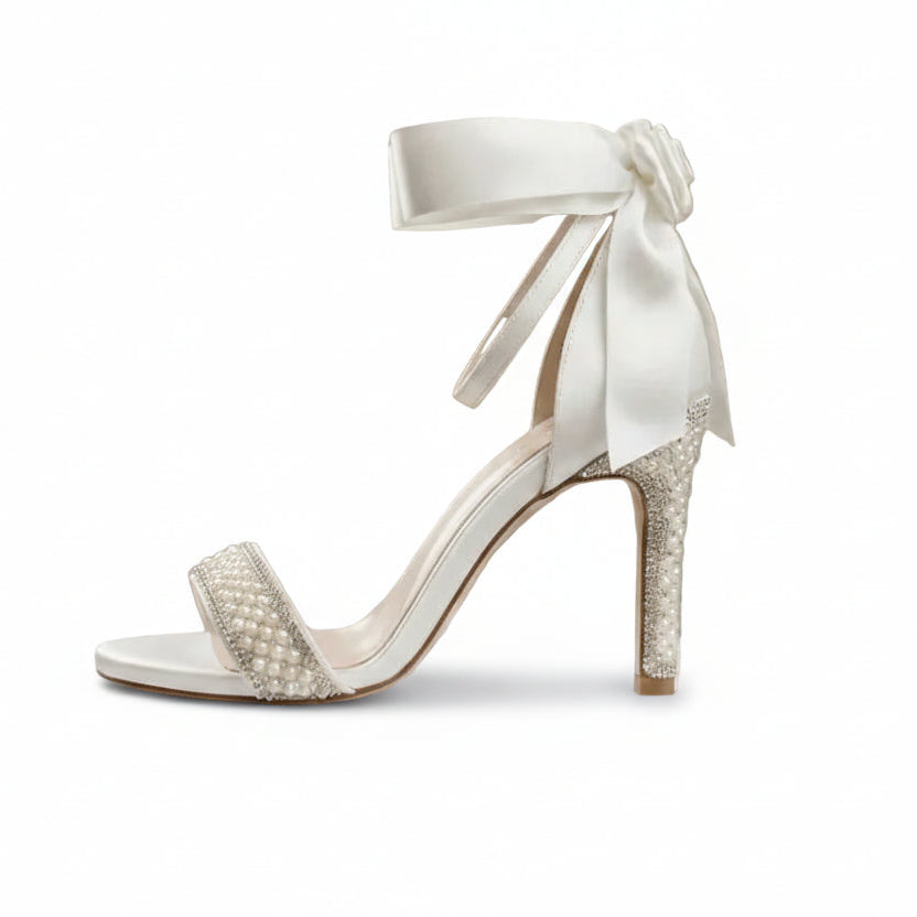 White wedding shoe with bow on a marble pedestal against a sparkling background wedding dress beirut