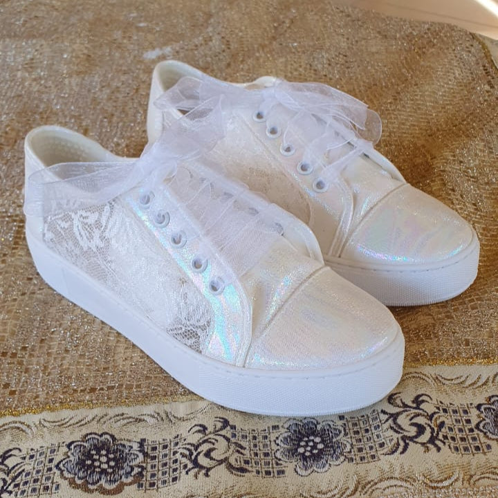 White Lace Bridal sneakers with lace details on a patterned tablecloth