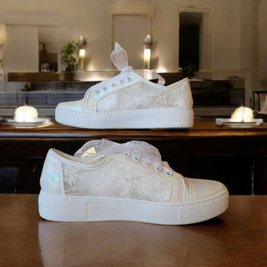 White sneakers on a wooden table with a blurred background