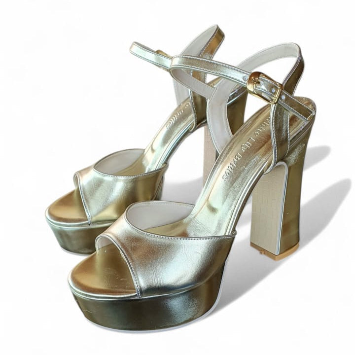 Gold high-heeled sandals on a white background