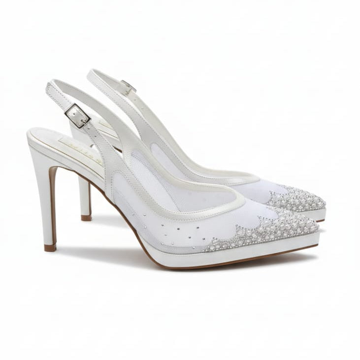 White high-heeled shoes with studded details on a white background