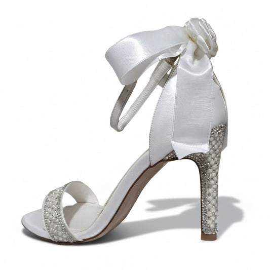 Side profile of a 10cm white satin bridal sandal featuring a large ankle bow and pearl-encrusted heel.