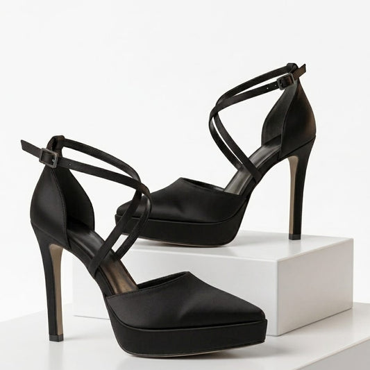 Black high-heeled shoes on a white platform with a white background