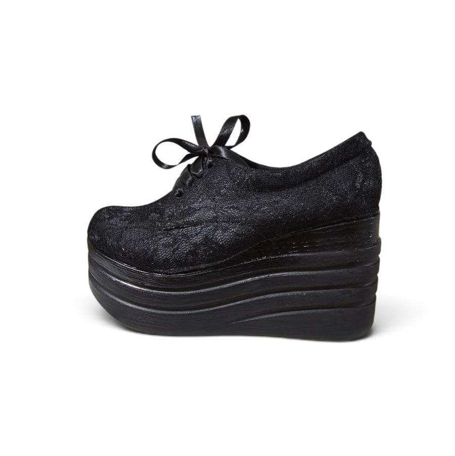 A single black lace-up platform shoe with a textured, jacquard-like fabric upper, shown from a side profile view against a plain white background.