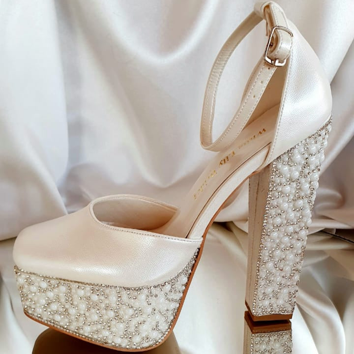 Beige high-heeled shoe with pearl embellishments on a white satin background in Beirut Lebanon