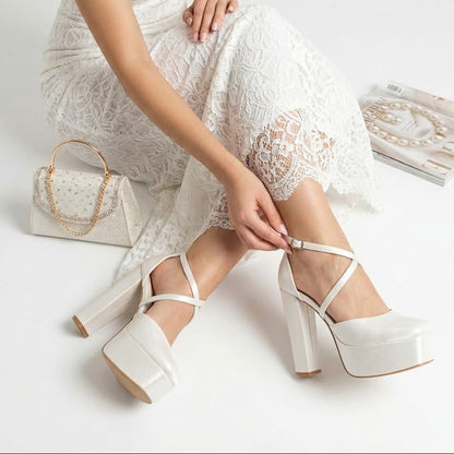Bride wearing  16 cm white high-heeled wedding shoes with a matching handbag on a light background in Beirut Lebanon 
