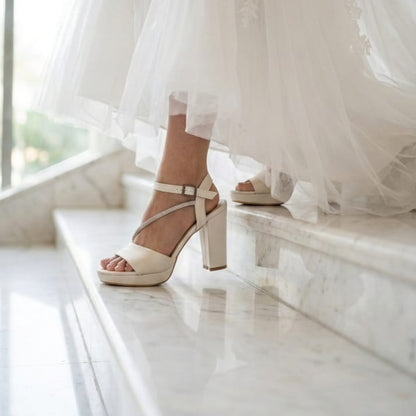 White wedding dress with a close-up of Comfortable Pearl white Bridal high-heeled shoes Sandals on a marble floor in Beirut Lebanon.