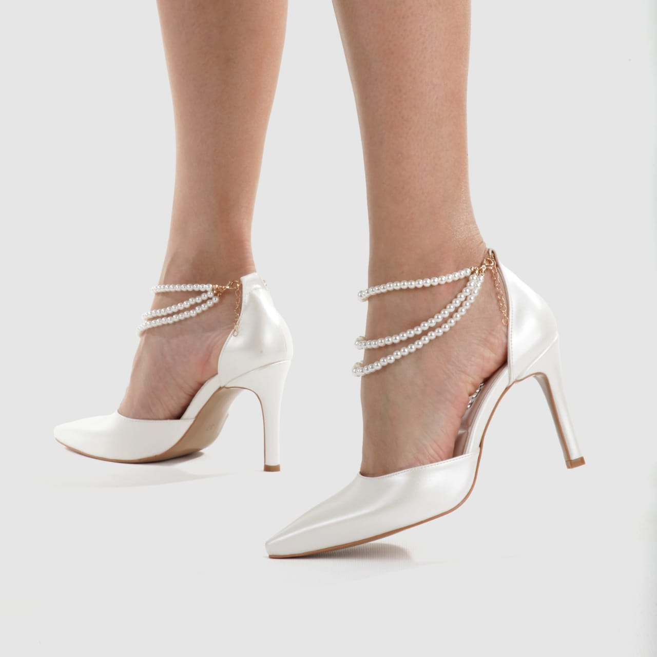 Elegant white bridal heels featuring a triple strand pearl strap and 8cm heel for wedding and formal wear. Beirut Lebanon