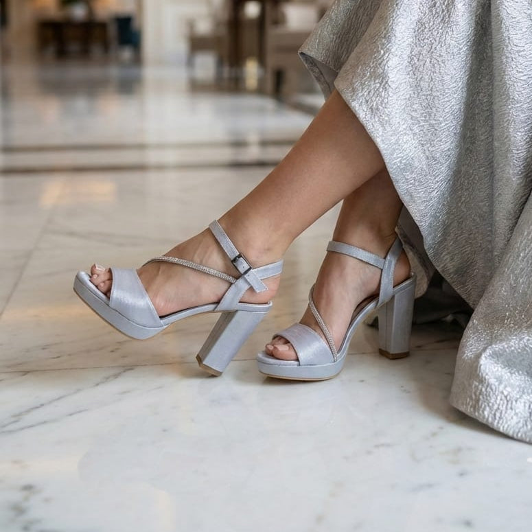 Person wearing Trendy silver Satin high-heeled sandals in a marble interior lobby in Beirut Lebanon