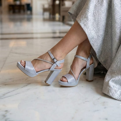Person wearing Trendy silver Satin high-heeled sandals in a marble interior lobby in Beirut Lebanon