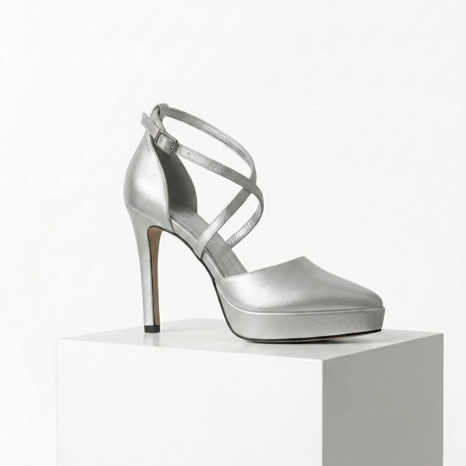 Silver high-heeled shoe on a white pedestal with a white background