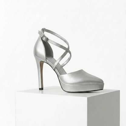 Silver high-heeled shoe on a white pedestal with a white background