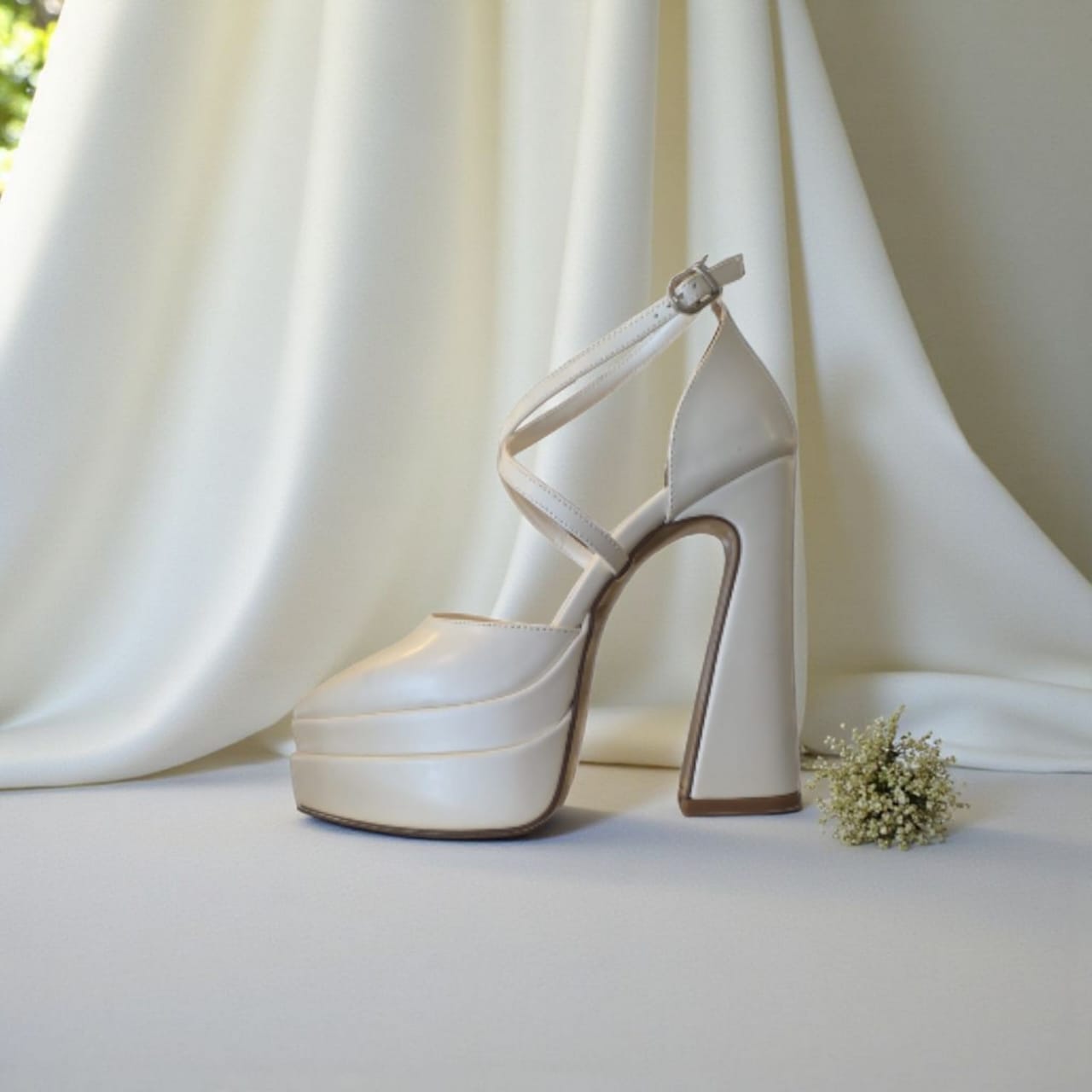 White high-heeled shoe with platform on a light background
