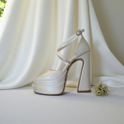 White high-heeled shoe with platform on a light background