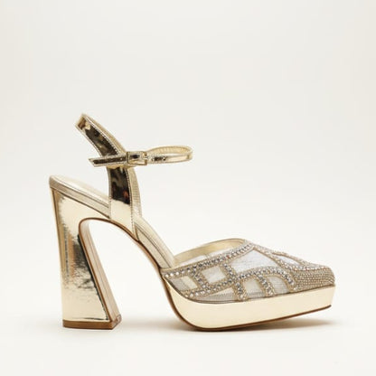 Gold high-heeled shoe with intricate design on a white background, featuring the brand 'B3N Milano'.