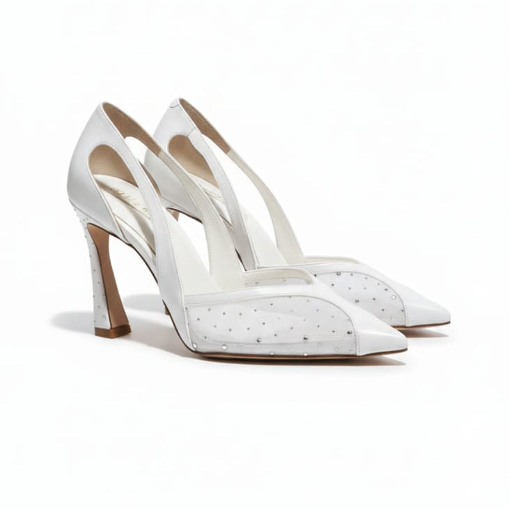 White high-heeled shoes with studded details on a white background