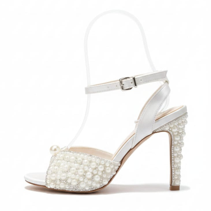 White sandal with pearl embellishments on a white background