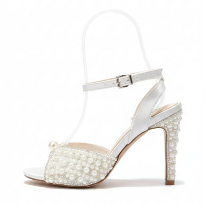 White sandal with pearl embellishments on a white background