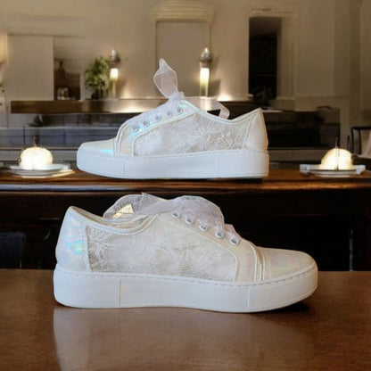 White sneakers on a wooden table with a blurred background
