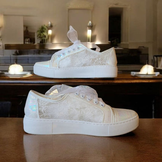White sneakers on a wooden table with a blurred background