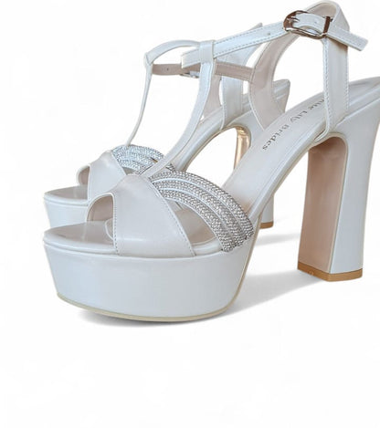 White high-heeled sandals with a platform sole on a white background