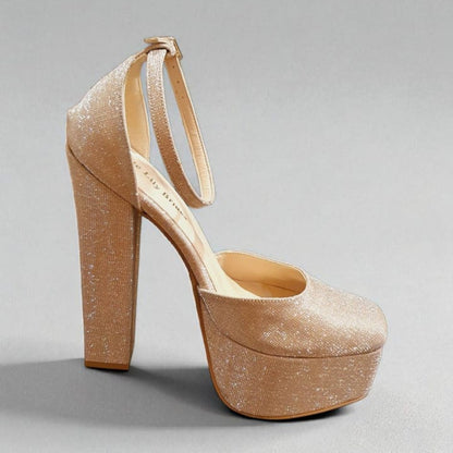 Gold high-heeled platform shoe on a gray background