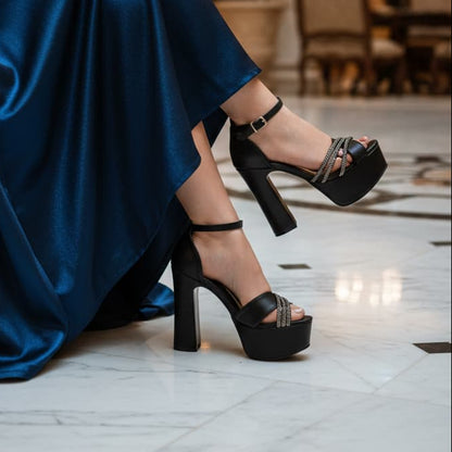 Person wearing a blue dress and black high-heeled shoes in an elegant indoor setting.