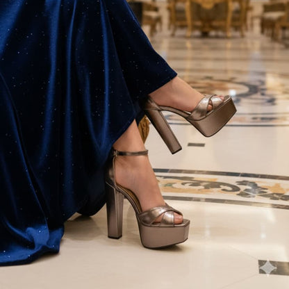 Person wearing metallic high-heeled shoes on a marble floor