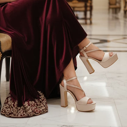 Person wearing a burgundy dress and high-heeled shoes in an elegant indoor setting.