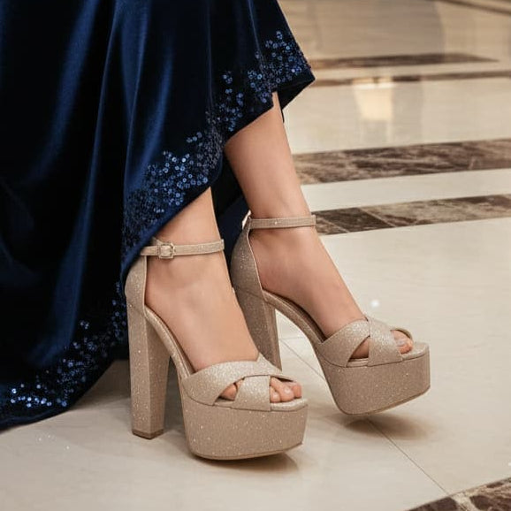 Woman in a long blue dress with sequins sitting in a luxurious room.