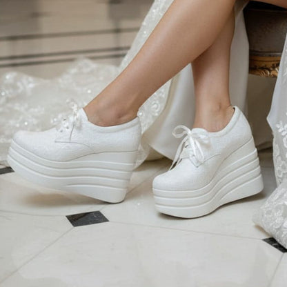 Bride wearing a white lace dress and Bridal Sneakers platform shoes 