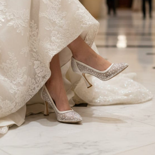 Bride in a white dress with sparkling high heels in a grand hallway.