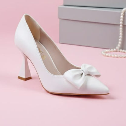 White high-heeled shoe with a bow on a pink background