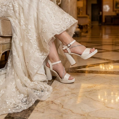 Bride in a wedding dress with white high-heeled shoes