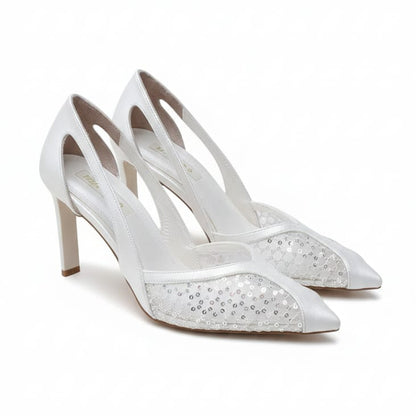 White high-heeled shoes with decorative details on a white background
