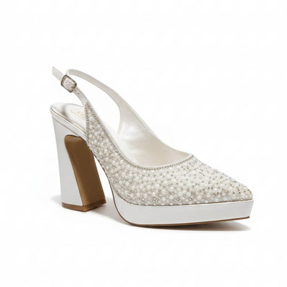 White high-heeled shoe with pearl embellishments on a white background