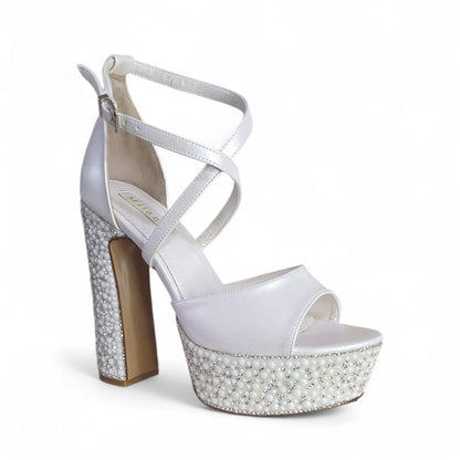 White high-heeled sandal with pearl embellishments on a white background