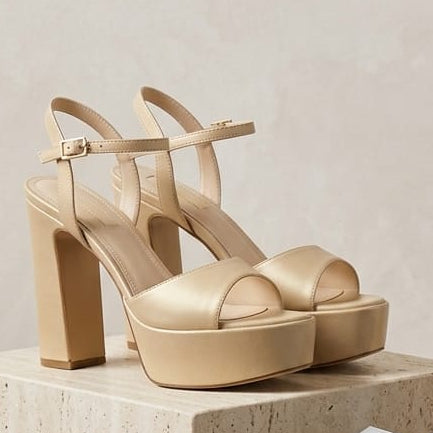 Gold high-heeled shoes on stone plinths