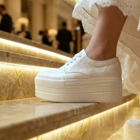 White wedding platform sneakers on a marble staircase in an elegant interior setting