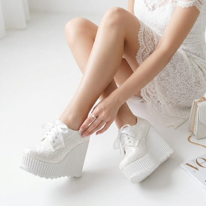 White lace-up Bridal  platform sneakers shoes worn by a bride sitting on a white surface with a magazine and handbag in Beirut Lebanon