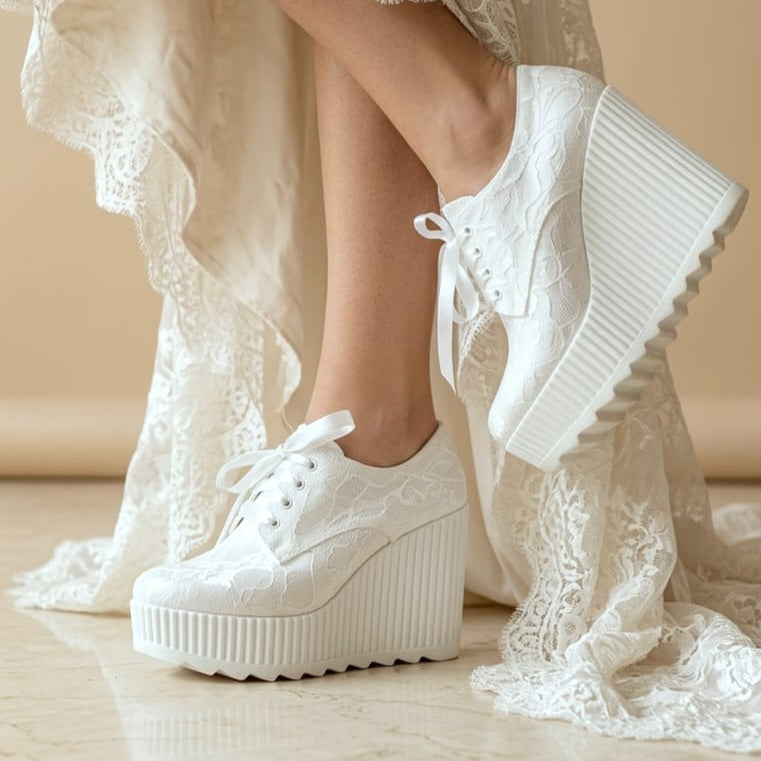 12 cm White lace-up platform sneakers with textured embossed detailing, shown on a bride wearing a cream wedding lace dress against a beige background.