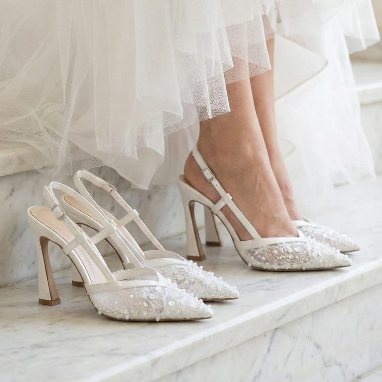 White lace wedding shoes worn with a white dress on a marble staircase Beirut.