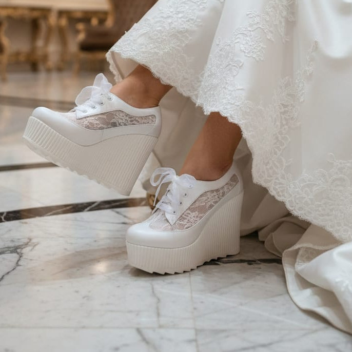 White platform sneakers with lace details worn with a white dress on a marble floor. in Beirut Lebanon