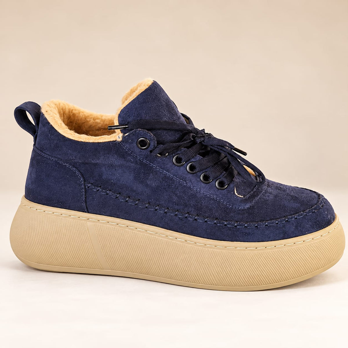 Front three-quarter view of navy blue women's casual winter sneakers with lace-up closure, soft fur-style lining, and beige platform soles