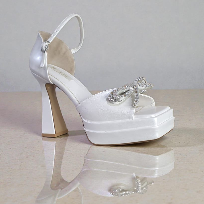 Smooth white bridal platforms with crystal bow detail. 
