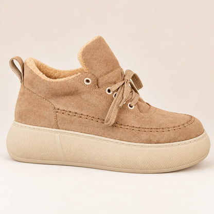 Side view of a camel beige women's platform sneaker with cozy fleece lining, rounded toe and cream rubber sole on a light beige background.