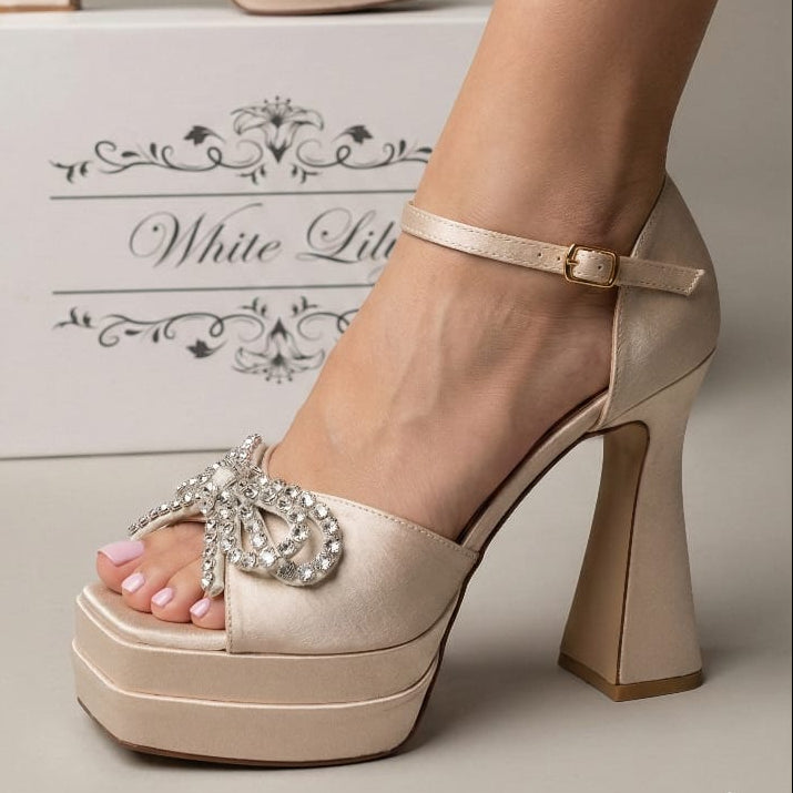 champagne shimmer platform high heel shoe with a crystal bow embellishment and ankle strap