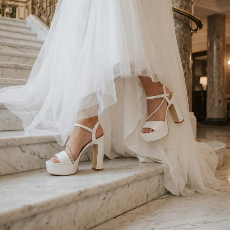 White wedding dress with high-heeled bridal sandal shoes double semelle on marble steps in a grand interior setting in Beirut Lebanon