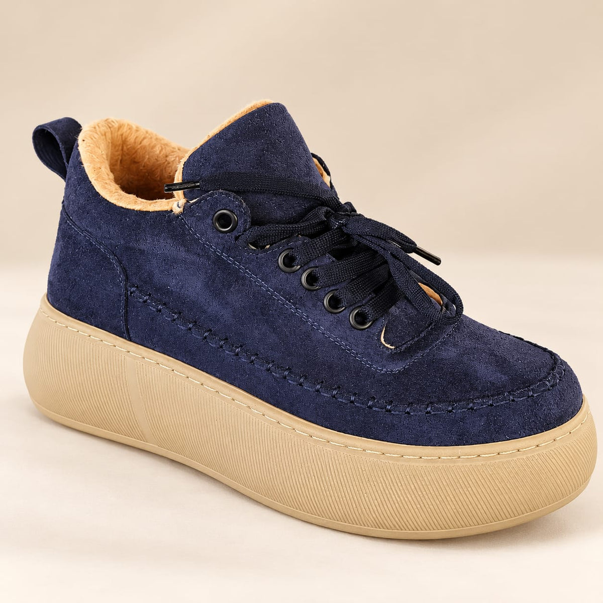 Side view of women's midnight navy platform sneakers featuring moc-toe stitching, cozy tan plush lining, and elevated beige soles