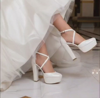 White wedding dress with bridal high-heeled shoes on a marble floor 